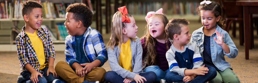 Image of happy children sitting on the floor in a library.