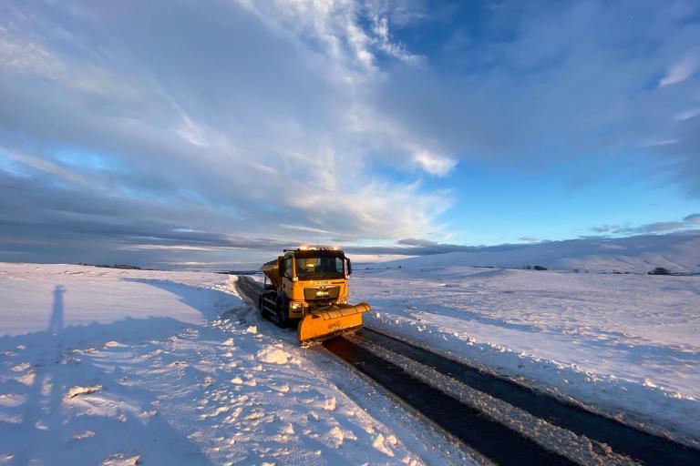 Yellow Gritter in Caldbeck during snowy weather