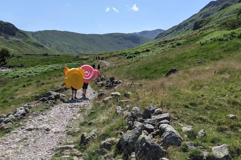 two children walking with inflatables in the lake district