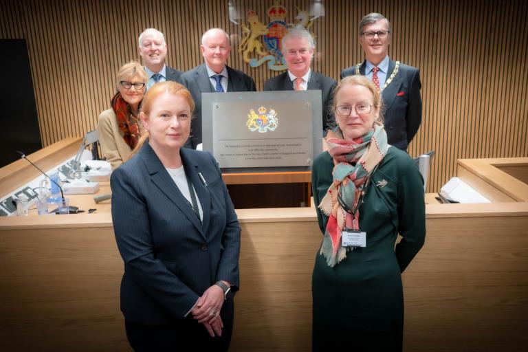 People standing at the front of the new coroner's court next to plaque that was unveiled during opening ceremony
