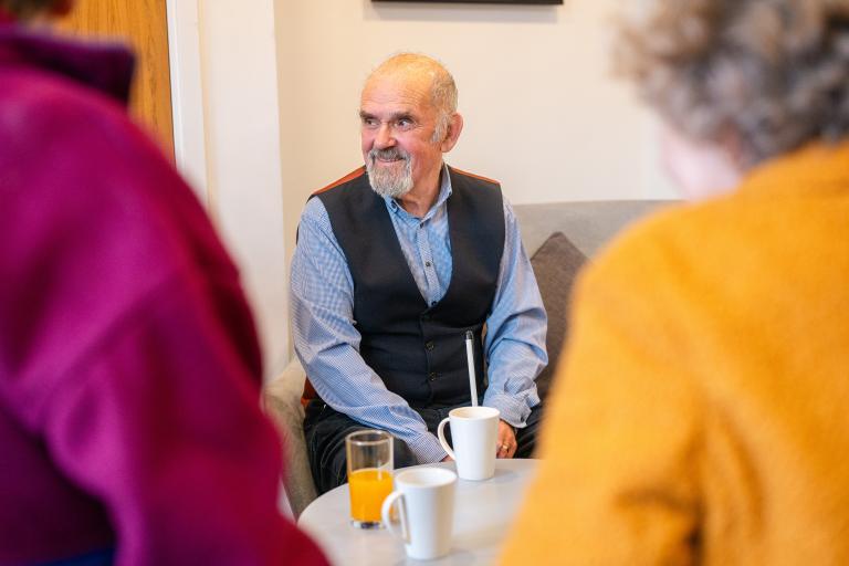 A man sat down with a group of people having a drink