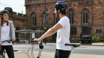 A woman and man standing with bikes in Carlisle City Centre