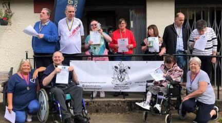 Group of adults hold certificates proudly outside of Vulcan Park bowls club