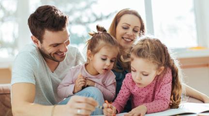 Dad, mum and daughters drawing at the table