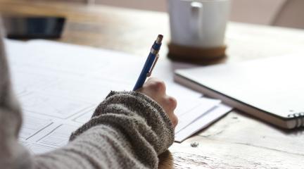 Someone writing in a notebook
