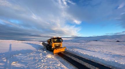 Yellow Gritter in Caldbeck during snowy weather 
