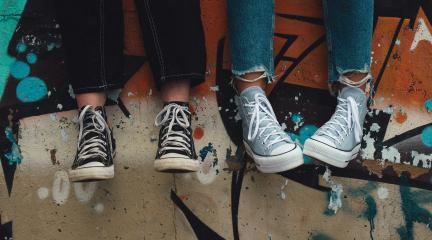 Young people's lower legs, in jeans and Converse shoes