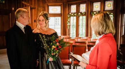 Two people getting married stood next to a ceremonies officer