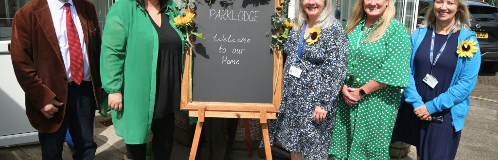 Cllr Martin Harris, Janice Lowery, Alison Glanville and representatives from Hospice at Home stand by welcome board to room opening