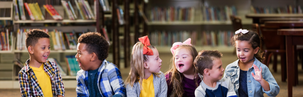 Image of happy children sitting on the floor in a library.