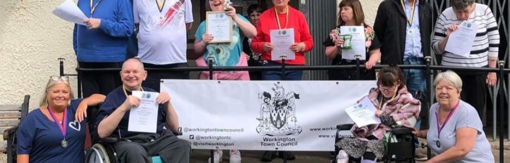Group of adults hold certificates proudly outside of Vulcan Park bowls club