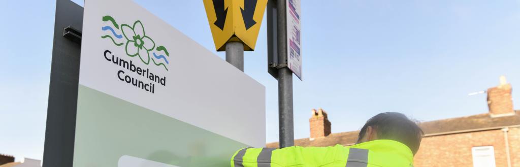 person stood next to a car parking sign
