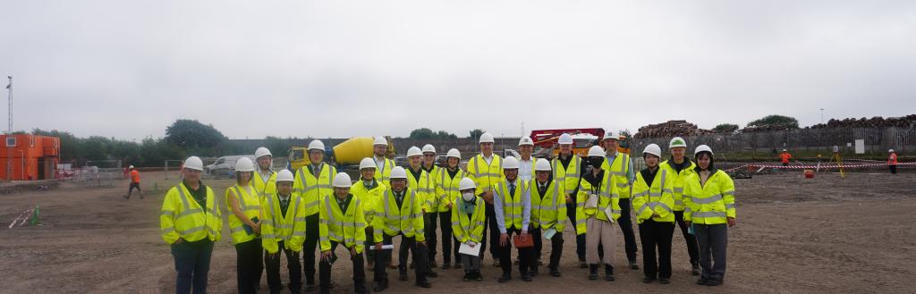 people stood at the port of Workington site which is to be developed in hi-viz jackets and hard hats