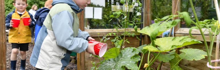 Two children watering plants