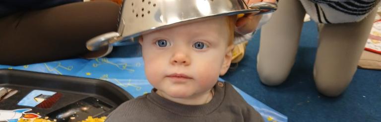 Child with a colander on their head