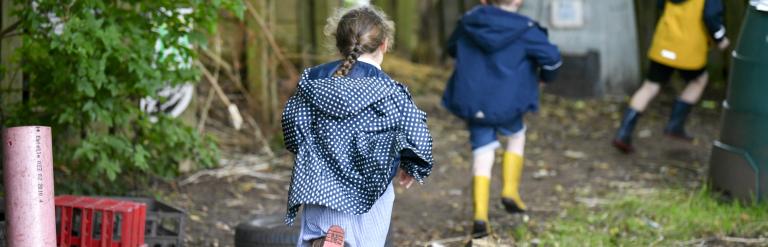 Two pre-school children running in the garden
